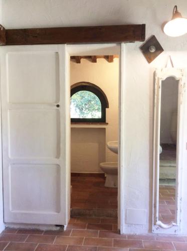 an open door to a bathroom with a toilet at Relais Casale Il Poggetto - I PINI by Zoom In Earth in Cecina