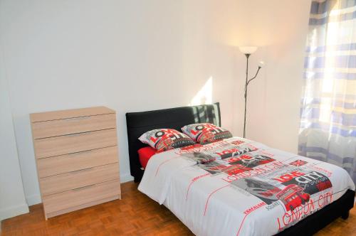 une chambre avec un lit et une commode dans l'établissement Appartement Reims près des maisons de champagne, à Reims