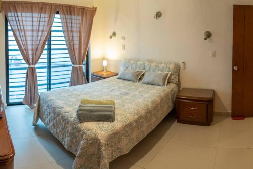 Un dormitorio con una cama grande y una ventana en Hermoso departamento en Paseo Santa Lucia, en Monterrey