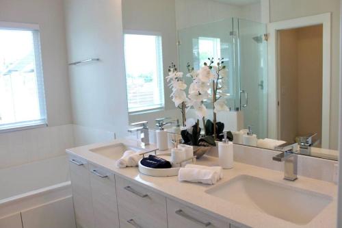 a bathroom with a sink and a large mirror at Modern Minimalist Luxury Retreat in Houston
