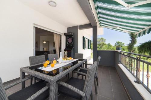 balcón con mesa y sillas en Family Villa Old Garden with heated swimming pool and private tavern en Opanci