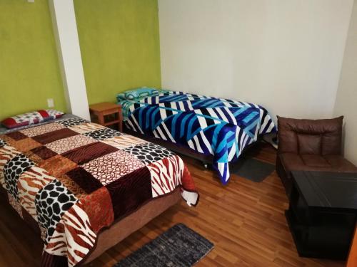 a room with two beds and a chair in it at H.Espejo in Copacabana