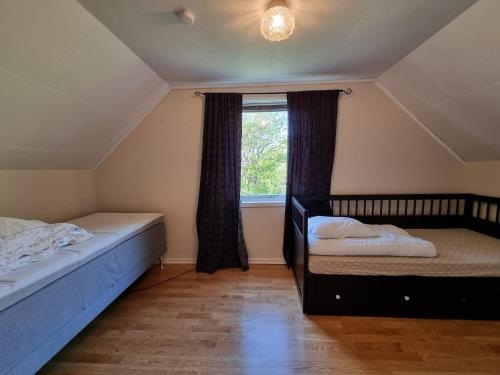1 dormitorio con 2 camas individuales y ventana en Nappstraumen Seaview holiday home en Haug
