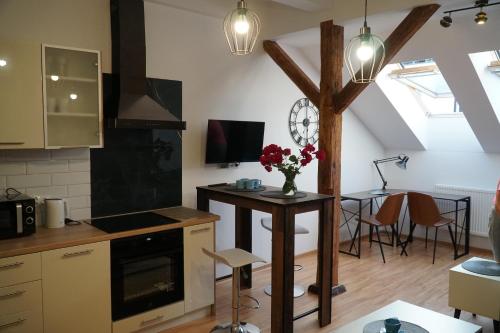 a kitchen with a table with flowers on it at Apartament w centrum OSTOYA 1 in Ełk