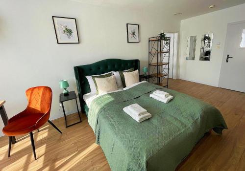 a bedroom with a green bed and a red chair at Great Polonia River Boat Apartments Wrocław in Wrocław