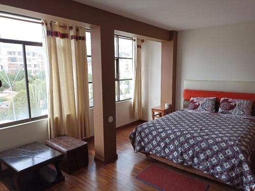 科帕卡巴納的住宿－H.Espejo，一间卧室设有一张床和两个大窗户
