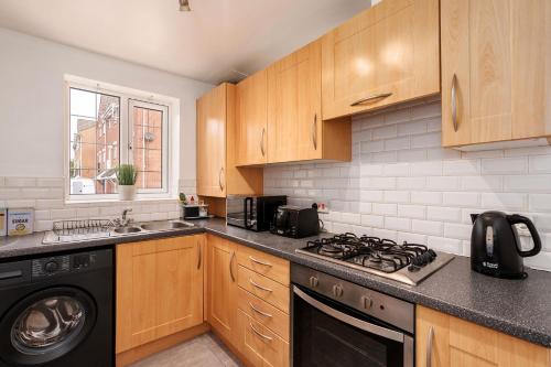 a kitchen with wooden cabinets and a stove top oven at Hills Close in Mexborough