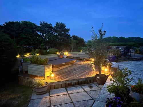 a backyard with a wooden deck at night with lights at Escape to A Luxury Country Home 