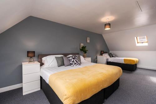 a bedroom with two beds and a blue wall at Hills Close in Mexborough