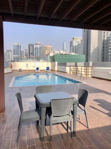 a table and chairs on a roof with a swimming pool at Wonderful 1BD With Full Marina View in Dubai