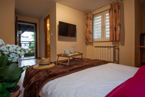 a bedroom with a bed with a table and a tv at Dom Pod Jeleniem in Łeba