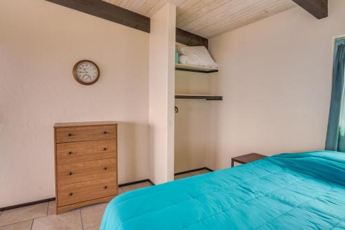 Un dormitorio con una cama y un reloj en la pared. en Captain Cook Bungalow with Panoramic Ocean Views!, en Papa Bay Estates