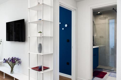 a room with a blue door and white shelves at Corfu Lux City in Agios Rokkos