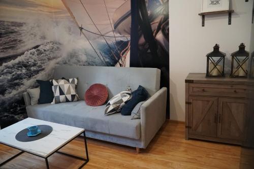 a living room with a couch and a painting on the wall at Apartament w centrum OSTOYA 1 in Ełk