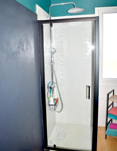 une douche avec une porte vitrée dans une salle de bain dans l'établissement À 2mn de la plage, maison avec grand terrain clos, à Plérin
