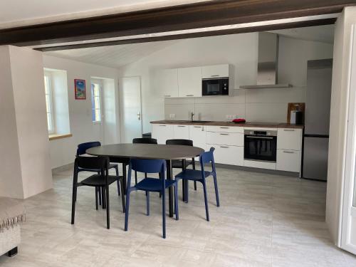 une cuisine avec une table et des chaises dans une pièce dans l'établissement Maison de pays la Chefmaliere, à La Cotinière