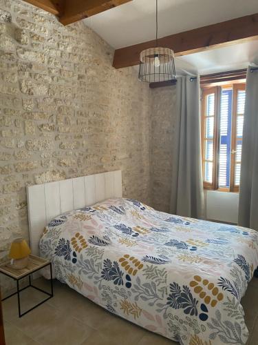 une chambre avec un lit et un mur de briques dans l'établissement Maison de pays la Chefmaliere, à La Cotinière