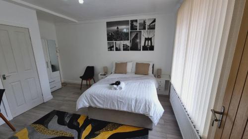 a bedroom with a bed with a cat sitting on it at Modern 3 bedroom house, 3 Bathroom, secure parking, Wi-Fi & Garden in Leeds