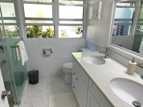 Woodlands的住宿－Oceanfront 3 bedrooms, 4beds, AC, WiFi, luxury villa，一间带两个盥洗盆、卫生间和窗户的浴室