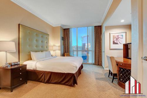 a hotel room with a bed and a desk and a window at MGM Signature-30-721 1Br2Ba F1 Strip View Balcony in Las Vegas