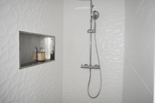 La salle de bains est pourvue d'une douche et d'une télévision murale. dans l'établissement Dbarka7, à Sète