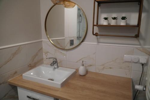 a bathroom with a sink and a mirror at Apartament w centrum OSTOYA 1 in Ełk
