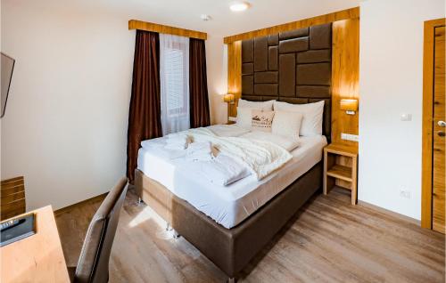 1 dormitorio con 1 cama grande y cabecero de madera en Amazing Home In St, Michael Im Lungau With Sauna en Sankt Michael im Lungau