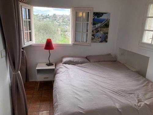 - une chambre avec un lit et 2 fenêtres dans l'établissement Appartement de Charme au calme Parking gratuit, à La Colle-sur-Loup