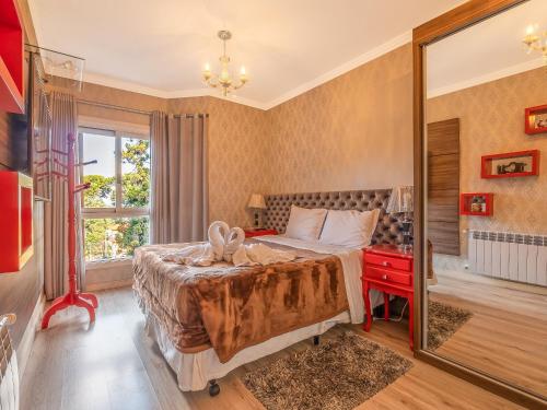 Un dormitorio con una cama grande y un escritorio rojo. en Vale das Hortênsias 204 II en Gramado