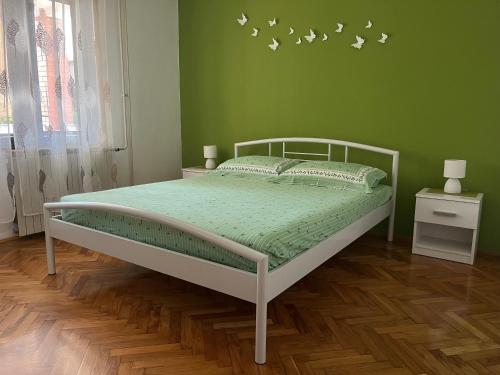 een groene slaapkamer met een bed met vogels aan de muur bij Annamaria Home in Pula