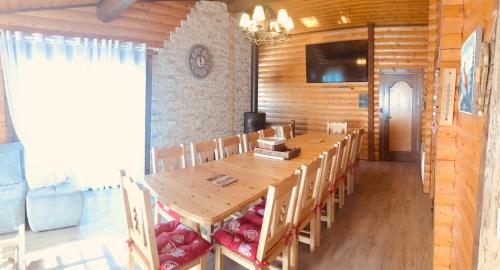 une salle à manger avec une grande table et des chaises en bois dans l'établissement El Chalet du Père Castor, à Bolquère-Pyrénées 2000