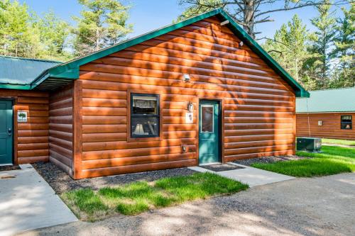 a log cabin with a green door at The Woodland in Conover