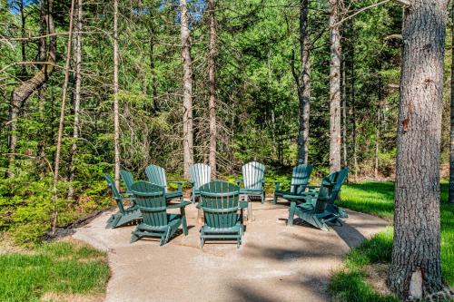 a group of green chairs and tables in the woods at The Woodland in Conover