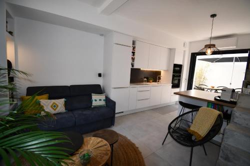 a living room with a couch and a kitchen at Maison de village rénovée ! in Le Grau-du-Roi
