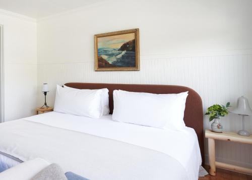 a white bed with white pillows in a bedroom at The Drifthaven at Gearhart in Gearhart