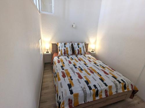 una camera da letto con un letto con una trapunta sopra di Le Saint Jean Cosy et Confort a Villefranche-de-Conflent