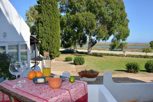 a table with a plate of fruit and a glass of wine at Waterfront apartment - 4 sleeps in Tavira
