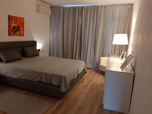 a bedroom with a bed and a table with a lamp at Port Lozenets Apartment in Lozenets