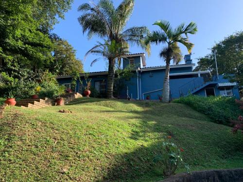 a blue house with palm trees in front of it at Maisha@Toti in Amanzimtoti
