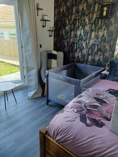 een slaapkamer met een bed in een kamer met een raam bij Beautiful MASONS HIDEAWAY studio apartment in Bridgend