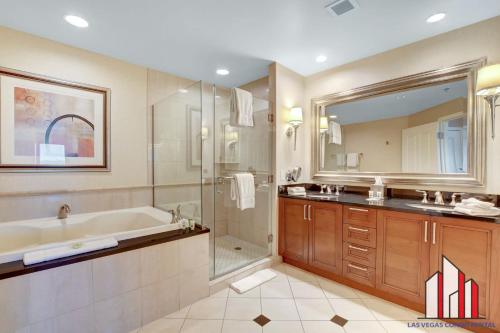 a bathroom with a tub and a shower and a sink at MGM Signature-33-705 F1 Track & Strip View Balcony in Las Vegas