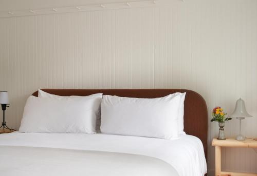 a bedroom with a bed with white sheets and pillows at The Drifthaven at Gearhart in Gearhart