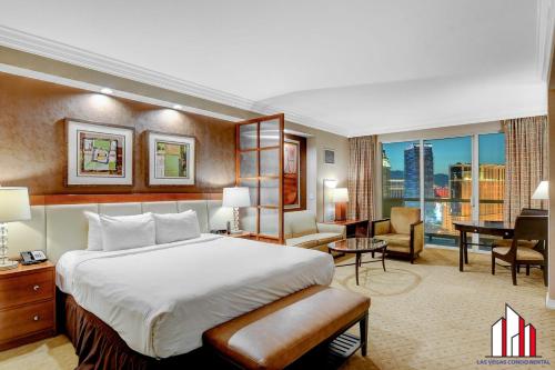 a hotel room with a large bed and a desk at MGM Signature-28-705 F1 Track & Strip View Balcony in Las Vegas