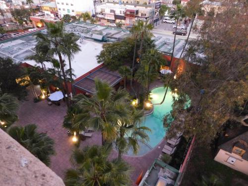 an overhead view of a swimming pool with palm trees at Hotel Palacio Azteca Tijuana, Trademark by Wyndham in Tijuana