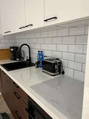 a kitchen counter with a sink and a toaster at Apartament Elle in Malbork