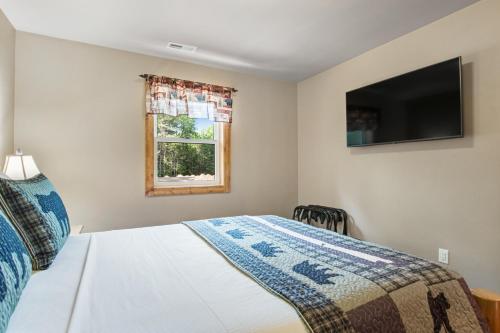a bedroom with a bed and a tv and a window at The Woodland in Conover