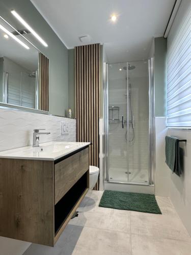 een badkamer met een wastafel en een douche bij PHEBUS in Berck-sur-Mer