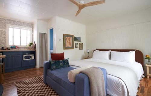 a bedroom with a large bed and a blue couch at The Drifthaven at Gearhart in Gearhart