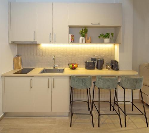 a kitchen with a sink and a counter with stools at Il Porto Blu in Chania Town