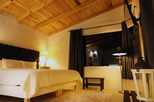 1 dormitorio con cama blanca y ventana grande en Cabaña El Encino III en Real del Monte, en Mineral del Monte